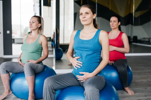 Hamile kadınlar dinlenme üzerinde the fitness topları.