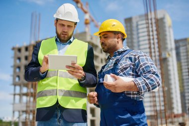 İki mühendis iş ile ilgili soruları birlikte tartışır.