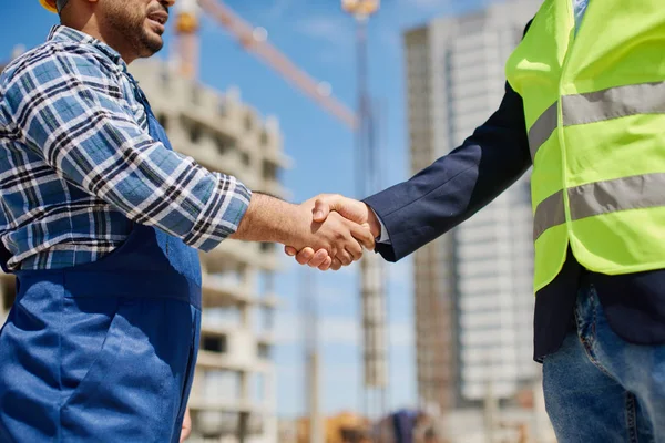 Zwei männliche Ingenieure schütteln einander freundlich die Hand. — Stockfoto