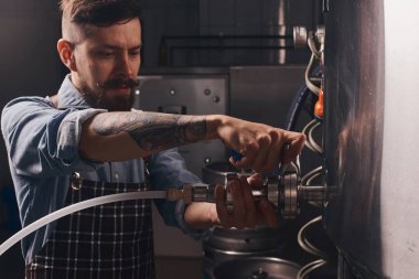 Bira üreticisi borular kullanarak varil bira türleri karışımları.