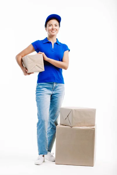 Trabajadora de reparto sostiene un paquete de cada tres que tiene . — Foto de Stock