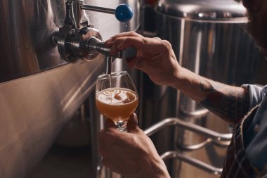 Barmen barda musluktan bira döker.