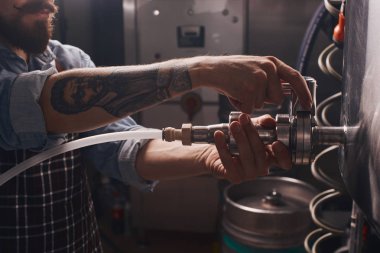 Varil muslukları kaldıran bir adamın yakın çekim.