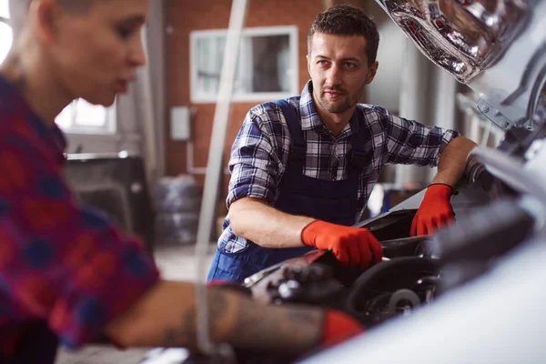 Automechanic apprend à son collègue comment nettoyer le moteur . — Photo