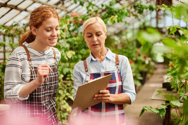 Not defterinde kontrol listelerini işaretleyen iki çiftçi.