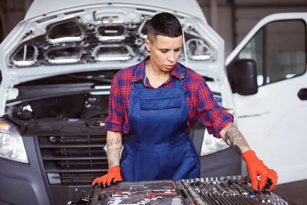 Femme travaille à la réparation automobile vérifier si elle a tous les instruments . — Photo