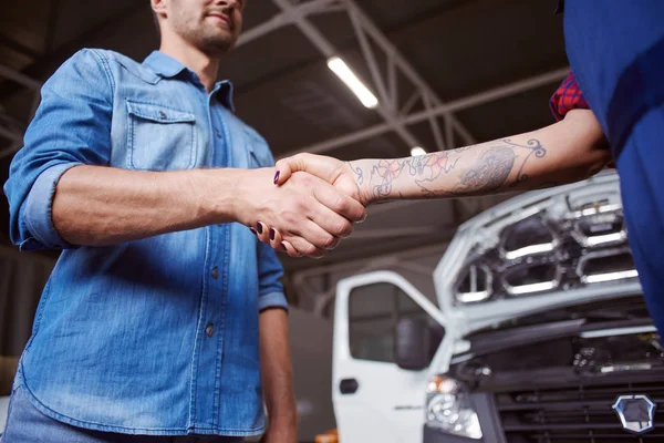 Propriétaire de voiture serre la main des mécaniciens comme le geste plein de gratitude . — Photo