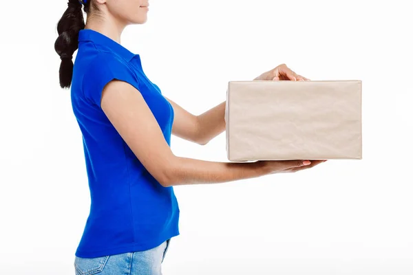 Primer plano de una chica con camisa azul mientras sostiene un gran paquete . —  Fotos de Stock