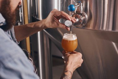 İşyerinde bira döken barmen yakın.