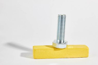 iplik ile metal cıvata ahşap bir çubuk üzerinde yatıyor