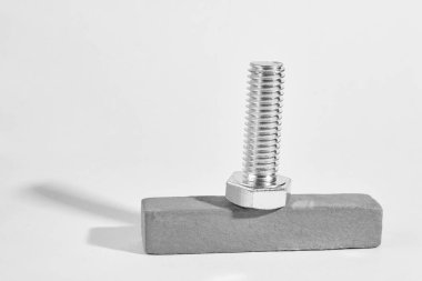 iplik ile metal cıvata ahşap bir çubuk üzerinde yatıyor