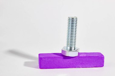 iplik ile metal cıvata ahşap bir çubuk üzerinde yatıyor