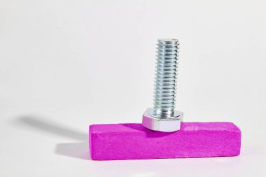 iplik ile metal cıvata ahşap bir çubuk üzerinde yatıyor