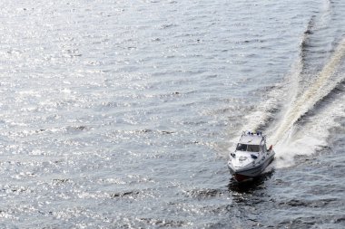 Baltık Denizi 'nin dalgalarında beyaz kayık kurtarma operasyonu, suda güzel bir parıltı ve teknenin su lekeleri.