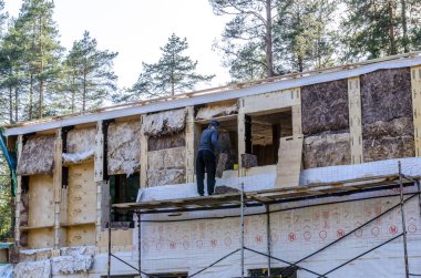 mineral yün bir çerçeve evin yalıtımı, kilitleri ile kontrplak yapılmış duvarlar.