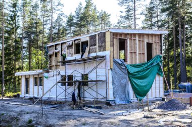 mineral yün bir çerçeve evin yalıtımı, kilitleri ile kontrplak yapılmış duvarlar.