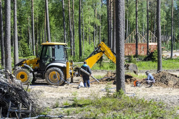 the work of a large two-wheeled tractor when laying water supply for water supply of private homes. the concept of building a country house.