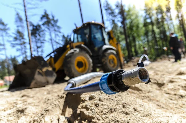 the work of a large two-wheeled tractor when laying water supply for water supply of private homes. the concept of building a country house.