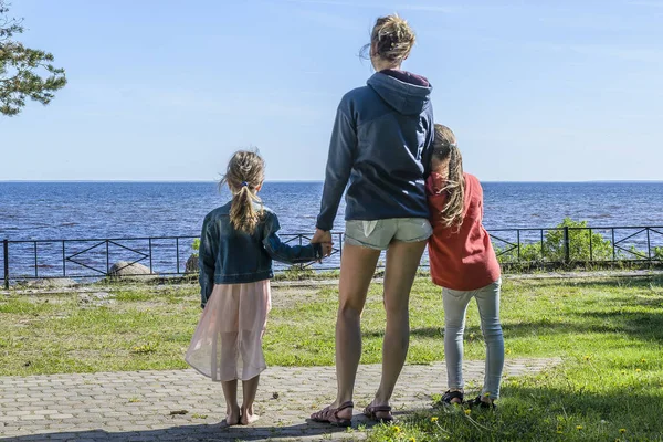 mom and daughters looking at the beautiful sea. the concept of family vacation.