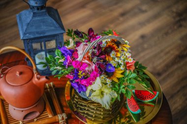              çiçekler ve ahşap bir masa ve ahşap bir zemin arka planda güzel bir siyah mum çubuğu ile çay kompozisyon.                  