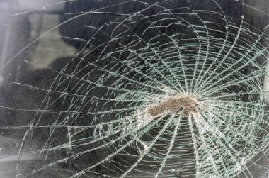 bir taş ya da parke taşı hızla arabaya uçtu gibi ön cam parçaladı. kırık bir ön cam parçaları ve izleri, doku çatlakları, boşanma çevreleri kavramı