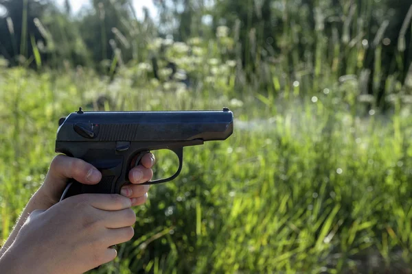 the shot and the exit gases from the pistol, the child holds the weapon with two hands.