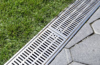 street separation stormwater drainage, for drainage and separation of water from the lawn and paving slabs. clipart