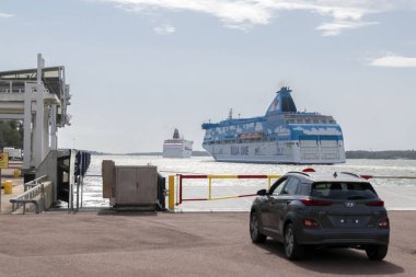 Finlandiya, Aland Adaları, Marienhamn Ağustos 2019: feribota geç kalan bir araba Mariehamn limanındaki rıhtımın kenarında duruyor. Uzağa gidiyor. İki büyük feribot Silja hattı ve Viking hattı..