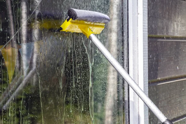 洗濯窓 ガラスや表面を掃除します 黄色の白い伸縮性洗浄ブラシをきれいに洗浄し 家の窓を拭く — ストック写真