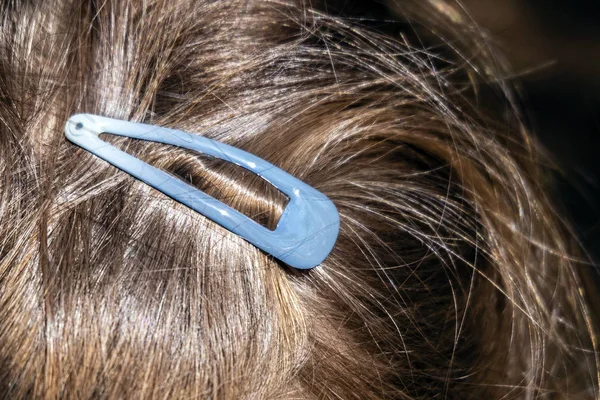 turquoise hair clip in the girl\'s hair, holds the hair and styling on his head.