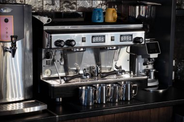 Espresso, cappuccino ve americano için profesyonel kahve makinesi, kafeler ve barlar, restoranlar, mataralar ve oteller için ideal. Yanında kaynar su ve kahve öğütücüsü olan bir kazan var..