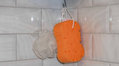 dikdörtgen turuncu plastik ve yuvarlak çevre dostu beyaz bez banyoda bir kancaya asılı fayans zemin