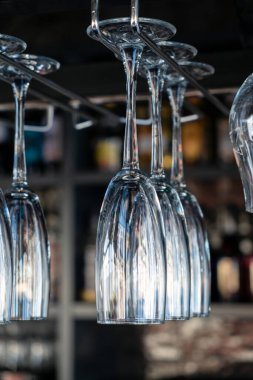 Kafede şampanyalı bardaklar baş aşağı duruyor. İçi cam kadehlerle dolu restoranlar var. Bir barın arka planında alkol şişeleri vardı..