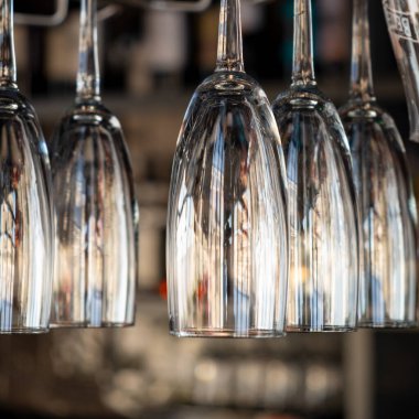 Kafede şampanyalı bardaklar baş aşağı duruyor. İçi cam kadehlerle dolu restoranlar var. Bir barın arka planında alkol şişeleri vardı..