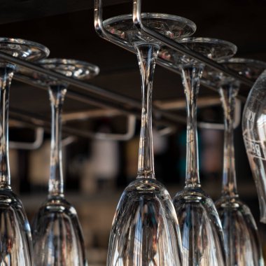 Kafede şampanyalı bardaklar baş aşağı duruyor. İçi cam kadehlerle dolu restoranlar var. Bir barın arka planında alkol şişeleri vardı..