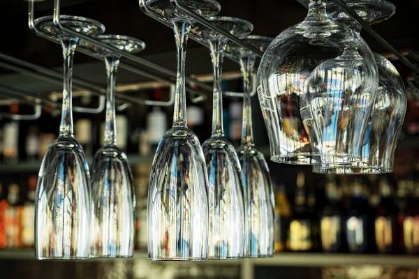 Kafelerde şampanyalı, viskili ve konyaklı bardaklar baş aşağı duruyor. Restoranların içinde de uzatılmış cam ve yuvarlak bardaklar var. Bir barın arka planında alkol şişeleri vardı..