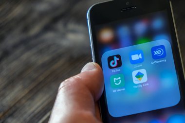 St. Petersburg, Rusya, Nisan 2020: İletişim ve eğlence için farklı uygulamalar Tik Tok, ZOM, Mi Home, Google uygulaması ahşap arka planda bir cep telefonunda el ele