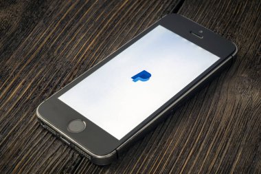 Rusya, St. Petersburg, Nisan 2020: Paypal, ABD 'li çevrimiçi ödeme ve bankacılık hizmetleri şirketidir. Ekranda PayPal uygulamaları olan Apple iPhone tahta bir arka planda yatıyor.