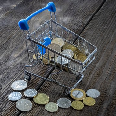 Çeşitli değerlerde bozuk paralarla dolu bir alışveriş arabası. Uluslararası kriz; para biriminin değer kaybı ve krizin soyutlanması.