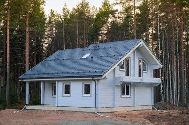 Çam koruluğunda inşa halinde modern bir ev. Şehir dışında inşaat, doğada, büyülü bir ormanda özel bir bölge..