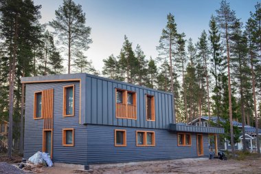 Çam koruluğunda inşa halinde modern bir ev. Şehir dışında inşaat, doğada, büyülü bir ormanda özel bir bölge..