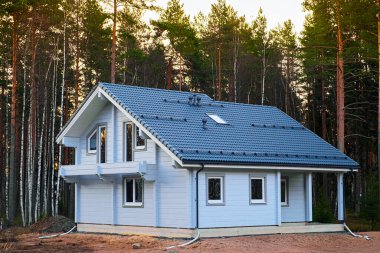 Çam koruluğunda inşa halinde modern bir ev. Şehir dışında inşaat, doğada, büyülü bir ormanda özel bir bölge..