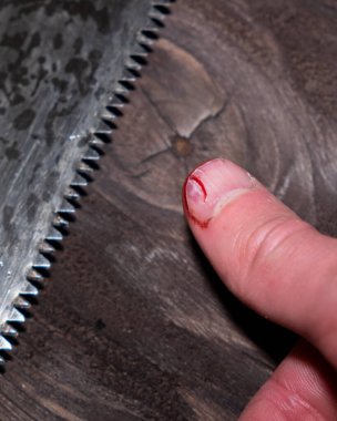 Endüstriyel bir yara, elinde kanla büyük bir baş parmak, bir adam testereyle parmağını yaraladı ve burnunu kanayarak kırdı..