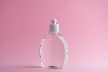 El dezenfektanı şişesi ya da pembe arka planda antiseptik jel.