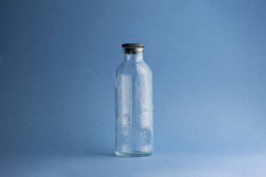 250 mililitrelik boş bir cam şişe. Bir damlacıktan veya diğer ilaçlardan 50 mililitrelik bir ölçek. Klasik mavi arka planda siyah bir kapağı var.