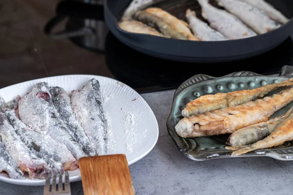 獲れたばかりの魚の匂いがするのは 小麦粉を入れた皿に盛り付けられ 皿で揚げられ フライパンで揚げられ 魚を調理する過程です — ストック写真
