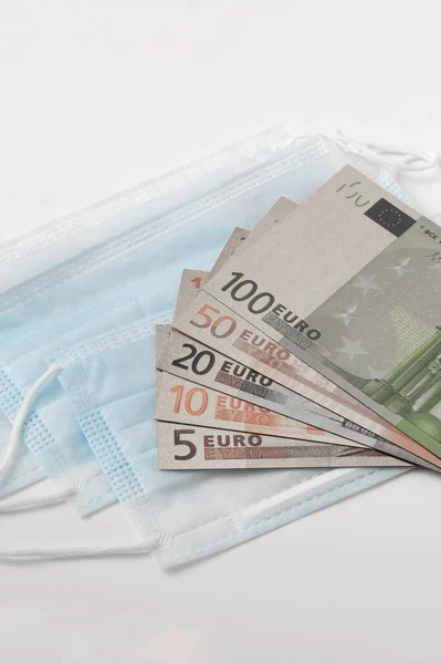 Ιατρικές Μάσκες Και Τραπεζογραμμάτια Ευρώ Που Έχουν Απομονωθεί Λευκό Φόντο — Φωτογραφία Αρχείου