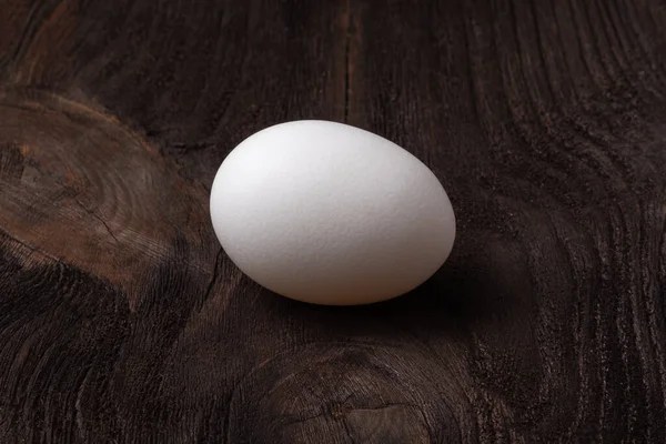Ein Weißes Gleichmäßiges Hühnerei Liegt Auf Einem Schönen Hölzernen Hintergrund — Stockfoto