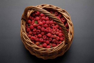 Kırmızı ahududulu sepet koyu gri-siyah arka planda. tatlı ve sağlıklı yiyecekler, sağlık için vitaminler