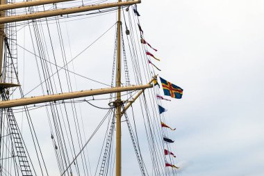 Bağımsız Aland Adaları bayrağı büyük bir yelkenlinin direğinde sergilenmektedir..